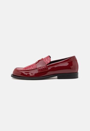 Lacklederschuhe in tiefem Rot, mit gewebter Struktur auf dem Obermaterial und einem niedrigen, gestapelten Absatz für Stabilität. Glatte, glänzende Oberfläche.