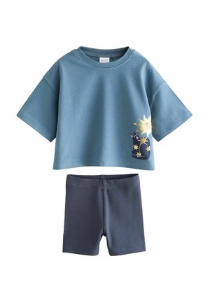 Cămașă albastră cu mânecă scurtă, cu grafică cu soare și pisică, asortată cu pantaloni scurți în dungi bleu închis, ținută casual pentru copii.