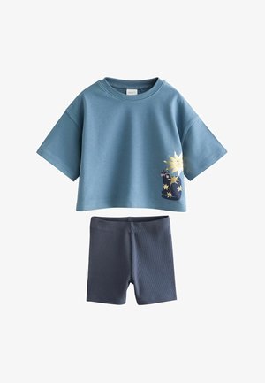 Kék rövid ujjú ing nap- és macskamintával, sötétkék bordás rövidnadrággal párosítva, gyerekeknek alkalmi ruházat.
