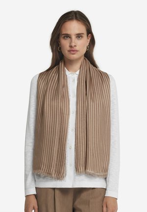 Écharpe rayée beige en matériau doux, avec des lignes texturées et des bords effilochés, portée sur une chemise blanche à boutons.