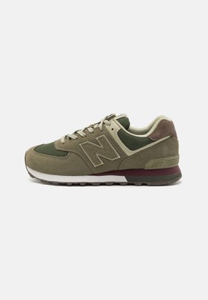 Sneaker New Balance verde oliva e beige con tomaia in suede e mesh, intersuola bianca e dettaglio bordeaux sul tallone.