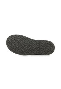 Zwarte rubberen schoenzool met een textuur van golfpatroon. Kenmerken zijn ribbelsecties voor grip en een centrale flexibele lijn.