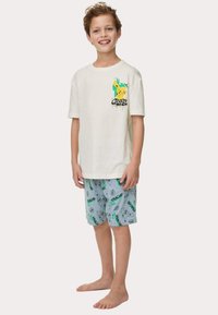 Witte katoenen T-shirt met een Pikachu-grafiek en de tekst "#0023", gecombineerd met blauwe shorts met Pikachu- en Pokébalpatronen.