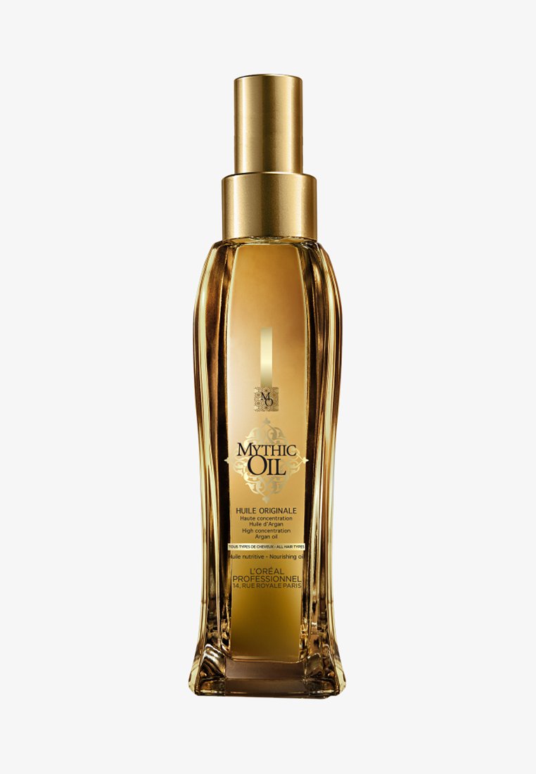 Tall, gold-tinted rectangular bottle of Mythic Oil with pump dispenser, labeled as high concentration argan nourishing oil for all hair types.