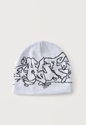 Bonnet en maille blanc avec un motif abstrait style graffiti noir au milieu sur un fond clair uni.