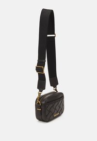 Borsa a tracolla in pelle nera con motivo intrecciato, hardware dorato e tracolla in tessuto nero. Chiusura con zip nella parte superiore e design piatto.
