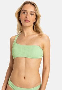 Top de bikini de color verde claro con un diseño asimétrico de un solo hombro, que presenta una textura suave y un color sólido.