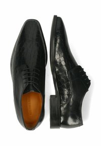 Zapatos de vestir de cuero negro con un patrón de cocodrilo texturizado, punta afilada y tacón plano con cordones en la parte delantera. El interior es de color marrón claro.