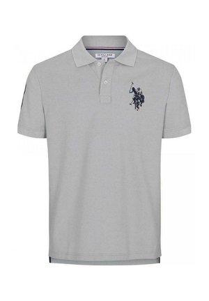 Grå kortærmet polo med broderet emblem på venstre bryst, kombineret med blå jeans og hvide sneakers.