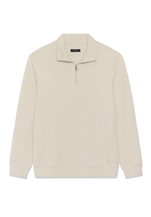 Bež pulover z visokim ovratnikom in polovičnim zadrgo, narejen iz mehkega materiala. Ima rebraste manšete in pas ter minimalen logotip.