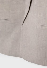 Tissu de veste de costume gris clair avec un motif à carreaux subtil, présentant deux poches avant et une texture lisse. Lignes épurées et design ajusté.