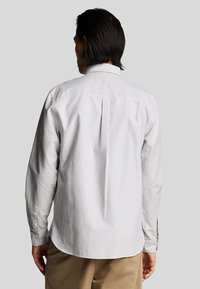 Camicia a maniche lunghe con un motivo a righe grigio chiaro e bianco, polsini con bottone e una piega sul retro per una vestibilità migliorata.