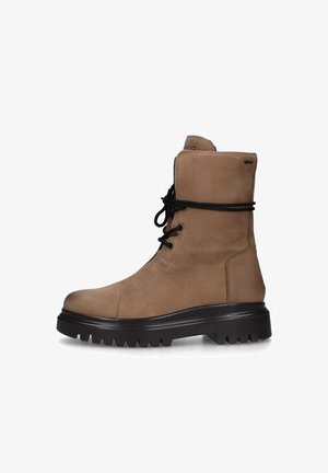 Stivaletti alla caviglia in suede beige con suola in gomma nera, lacci frontali, punta arrotondata e dettagli cuciti. Tallone rinforzato per un supporto extra.