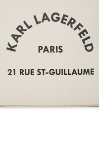 Plátená taška so čiernym textom "KARL LAGERFELD PARIS 21 RUE ST-GUILLAUME" na svetlom béžovom pozadí.