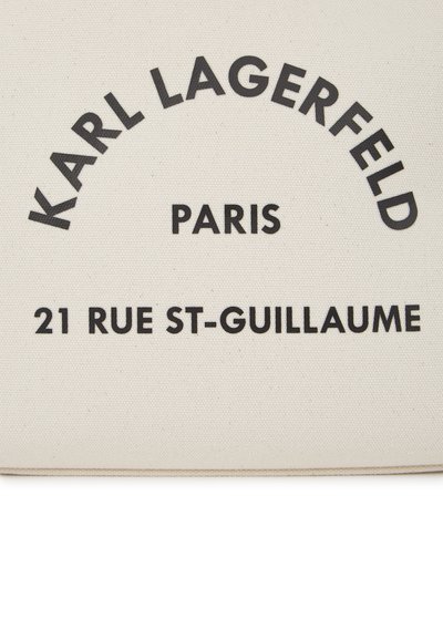 Торба от канва с черен текст, който гласи "KARL LAGERFELD PARIS 21 RUE ST-GUILLAUME" на светло бежов фон.