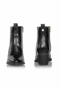 Czarne skórzane botki za kostkę z bocznym zamkiem błyskawicznym, niskim słupkowym obcasem i gładką fakturą. Posiadają uchwyt z tyłu.