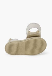 Sandalias de color claro con una suela de goma texturizada, correas de tela y un detalle trenzado en la plantilla. Talla 24 con la marca grabada.