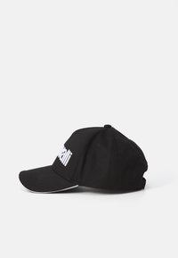 Schwarze Baseballmütze aus Baumwolle mit einem weißen gestickten Logo auf der Vorderseite, gebogenem Schirm und einem verstellbaren Riemen auf der Rückseite.