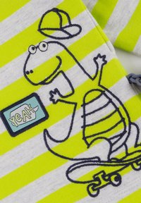 Striped grey and neon green fabric featuring an embroidered dinosaur with a skateboard and cap, accompanied by a "YEAH" patch.