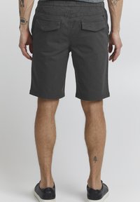 Shorts pour hommes gris foncé avec une coupe décontractée, taille élastique et deux poches arrière. Tissu en coton lisse avec une texture unie.
