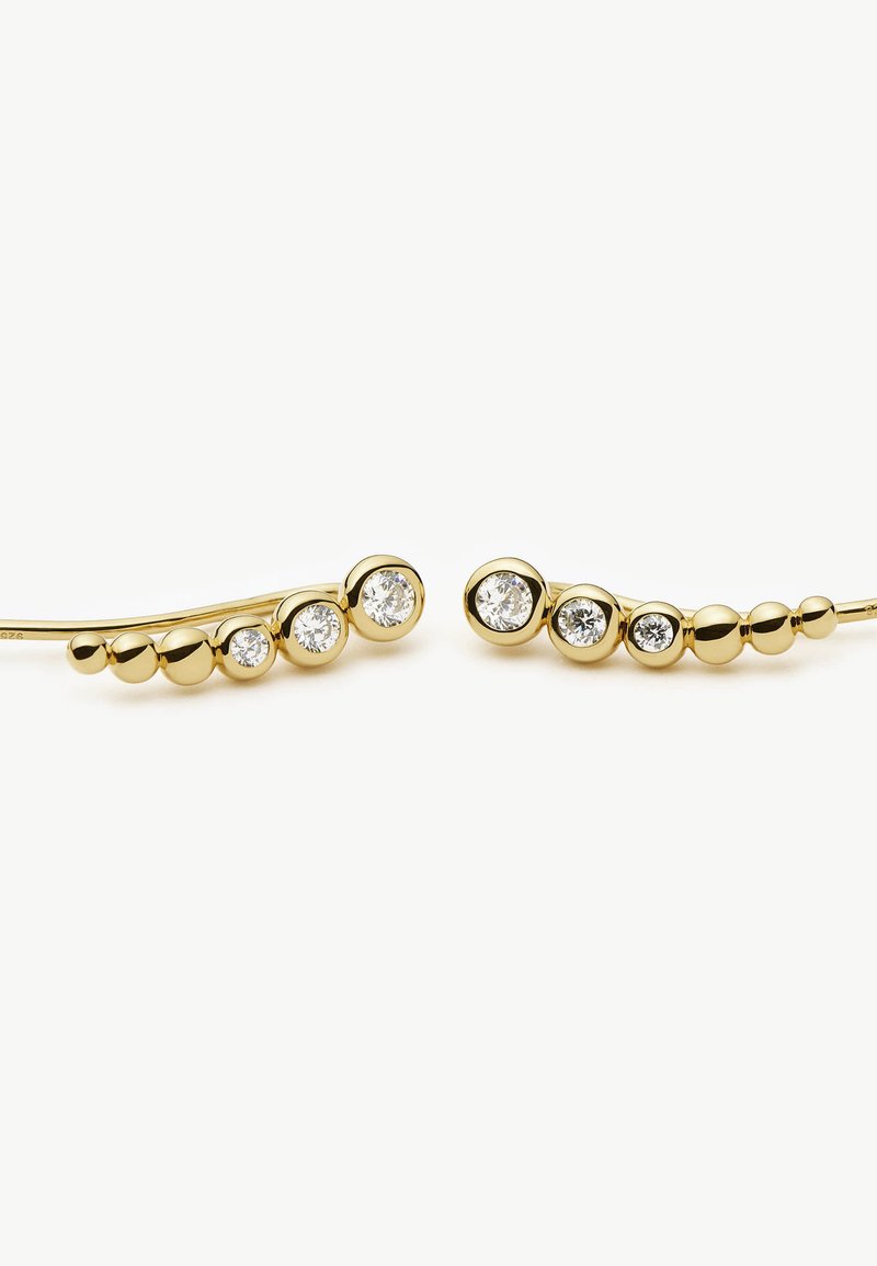 Brincos de ouro com um design linear e acentos esféricos de tamanhos variados, adornados com três pedras claras em cada brinco.