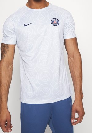 T-shirt blanc à manches courtes présentant un motif subtil sur toute la surface, un col rond et une patch logo bleu marine sur la partie gauche de la poitrine.
