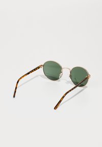 Runde Sonnenbrillen mit grünen Gläsern, goldenen Metallrahmen und arms in Schildpatt-Optik. Leichtes Design mit klaren Nasenpads für Komfort.