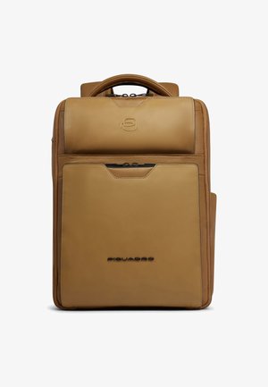 Mochila rectangular de cuero color canela con asa superior, bolsillo frontal con cremallera y logo de la marca en relieve en el panel frontal.