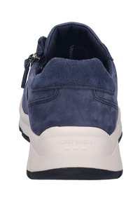 Marineblå ruskinds sneaker med polstret krave, hvid sål og lynlås lukning på siden. Har en tekstureret overflade og logo på hælen.