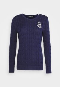 Marinblå kabelstickad tröja med långa ärmar, ribbade ärmslut och nederkant, med en vit logo och tre dekorativa knappar på axeln.