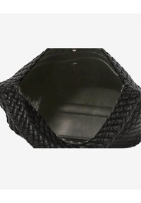 Musta kudottu käsilaukku, jossa on kuusikulmainen aukko, esitellen sileän, kiiltävän sisätilan ja monimutkaisen kudontakuvion koko ulkopinnalla.