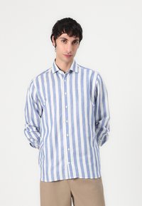 Camicia a righe blu e bianche, con bottoni e realizzata in tessuto leggero, caratterizzata da un colletto e maniche arrotolate; texture morbida, vestibilità casual.