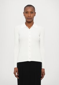 Witte ribgebreide lange mouwen cardigan met een kraag, voorzien van een knoopsluiting aan de voorkant en een getailleerd ontwerp. Glad textuur en lichte stof.