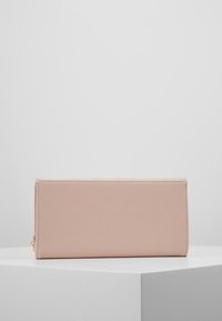 Obdélníková růžová peněženka z texturované kůže s hladkým povrchem a zipovým zapínáním. Jednoduchý design bez dalších ozdob.