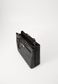 Sac fourre-tout en cuir noir avec une forme structurée, quincaillerie dorée, fermeture éclair, deux poignées et une poche extérieure pour une fonctionnalité supplémentaire.