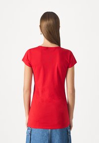 Red, short-sleeve t-shirt with a round neck, made of a smooth fabric. The back features a simple design, no patterns or embellishments.
