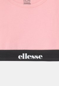 Rosa kortärmad t-shirt tillverkad av 96% bomull och 4% elastan, med ett svart elastiskt band med vit "ellesse"-logotyp i nederkant.