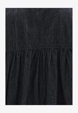 Musta farkku mekko, jossa on kerrottu vyötärö, pehmeä rakenne ja hienovarainen kiilto. Yksinkertainen muotoilu ilman lisäkuvioita tai koristeita.