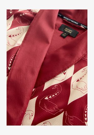 Červený a krémový kimono s potiskem labutí, texturovaným materiálem, širokým límcem a kontrastními vzory. Štítek nese nápis "ROCKETT & GEORGE."