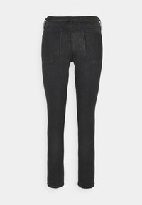 Jean slim en denim noir avec deux poches arrière et passants pour ceinture, vu de dos sur un fond clair uni.