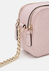 Różowa pikowana torba na ramię z złotym łańcuszkiem, podwójnym zamkiem błyskawicznym i kontrastowymi czarnymi akcentami, wykonana z teksturowanego materiału syntetycznego.
