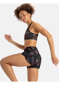 Black athletic set featuring a cropped sports bra and shorts with multicolored floral patterns. Simplistic design, soft texture, and elastic waist.