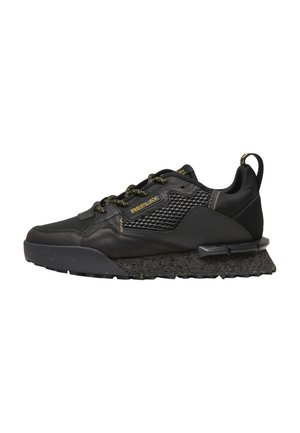 Zapatilla deportiva negra con suela texturizada, panel lateral de malla, logo amarillo "REPLAY" y cordones negros y amarillos, mostrada en perfil derecho.