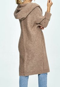 Long, knitted cardigan with a hood in light brown, featuring ribbed cuffs and hem, and a textured pattern. Side seam detail visible.