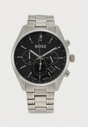 Silberne Chronograph-Armbanduhr aus Edelstahl mit schwarzem Zifferblatt, Tachymeter, Datumsanzeige bei 4 Uhr und Metallgliederarmband.