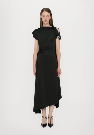 Schwarzes Midi-Kleid mit asymmetrischem Saum, gedrehtem Taillendetail und einer schulterfreien Rüsche. Der Stoff wirkt glatt und elastisch. Verstellbare Träger.