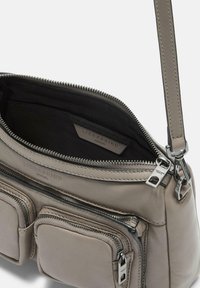 Borsa a tracolla in pelle grigia con un vano principale con zip, due tasche frontali con zip e dettagli in metallo argentato. Texture morbida.