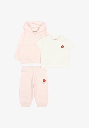 Completo da bambino piccolo di tre pezzi rosa chiaro con felpa con cappuccio e zip, maglietta bianca a maniche corte e pantaloni, ciascuno con un piccolo logo a fiore rosso.