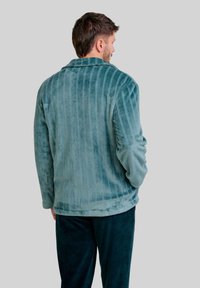 Chaqueta de forro polar en un teal suave con rayas verticales, un cuello de chal y textura acanalada; combinada con pantalones en teal oscuro a juego.