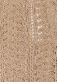 Tessuto beige lavorato a maglia con motivo a chevron e punti aperti, che mette in risalto la trama e la variazione di spessore del filo.